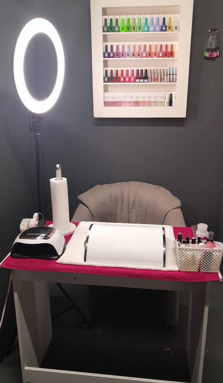 A Prostel Nails station with a ring light, UV lamp and a wall of gel polish colours